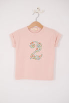 A Pink t-shirt with a Liberty Nazanin floral number '2' on a hanger against a white background