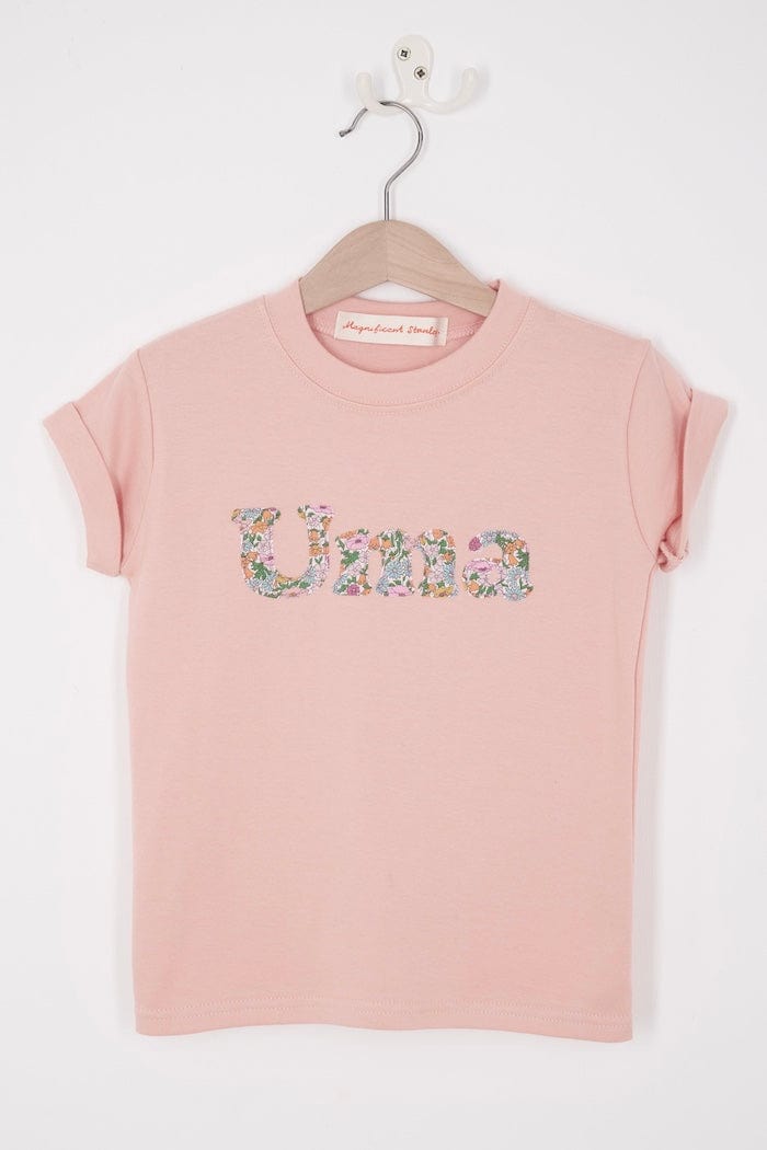 A soft pink kids t-shirt with her name cut from Liberty print in lowercase letters.