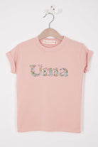A soft pink kids t-shirt with her name cut from Liberty print in lowercase letters.