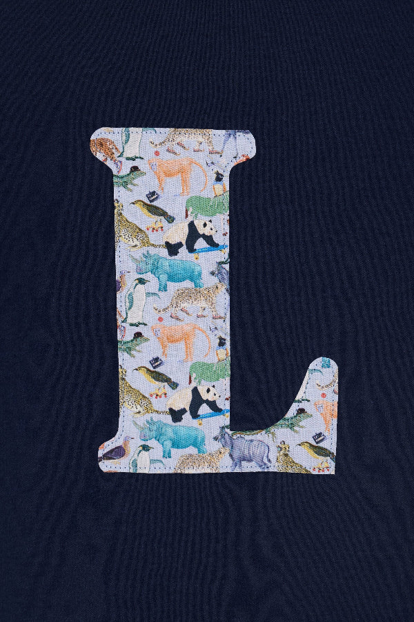  a close up of the stitching on a personalised kids navy t-shirt with an initial cut from quey 2 zoo animal liberty print on the front.
