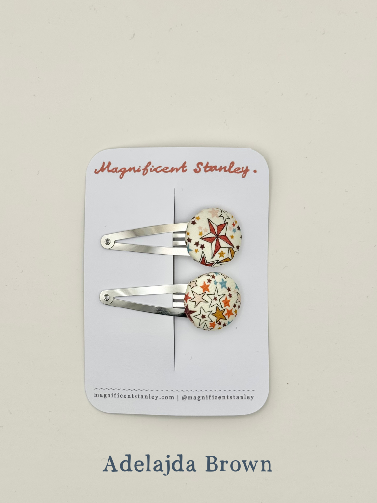 Two star print hair clips on a 'Magnificent Stanley' branded card in Adelajda Brown print