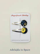 Two liberty bobble hair clips with colourful smiley face design in Adelajda in Space print on a 'Magnificent Stanley' card.