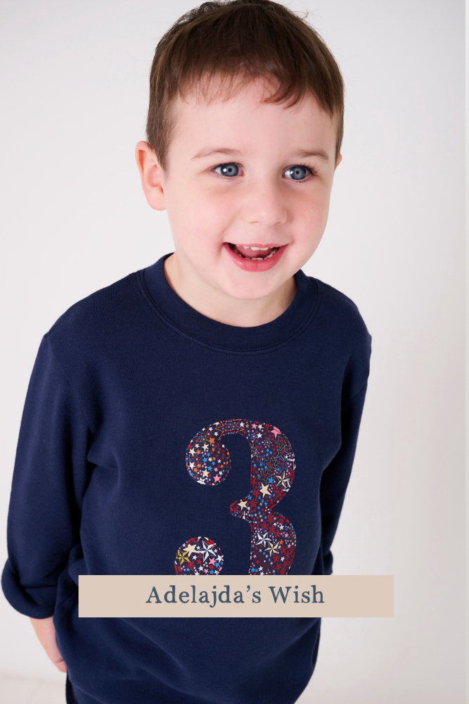 a smiling 3 year old boy wearing a navy birthday t-shirt with a number 3 cut from Adelajda's wish starry liberty print on the front.
