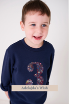 a smiling 3 year old boy wearing a navy birthday t-shirt with a number 3 cut from Adelajda's wish starry liberty print on the front.