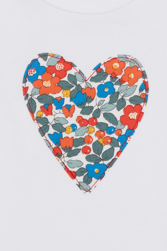 Heart-shaped fabric patch with floral pattern on a white background