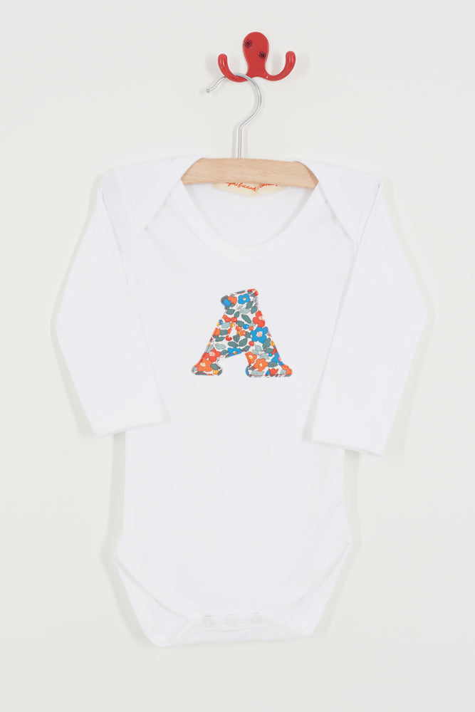 White baby onesie with colorful letter 'A' on a hanger against a white background