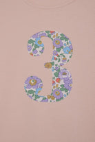a pink birthday t-shirt with a number 3 cut from betsy purple liberty floral print on the front