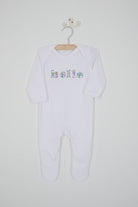 Close up of a white cotton romper with the word hello on it. the letters are cut from Betsy Purple liberty print and appliquéd onto the romper.
