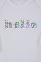 A white cotton baby bodysuit with the word hello made from Betsy Liberty Print sewn onto the front.
