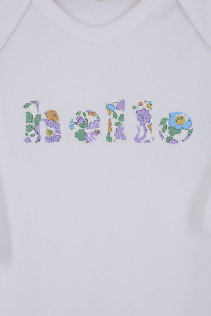 A white cotton baby bodysuit with the word hello made from Betsy Liberty Print sewn onto the front.