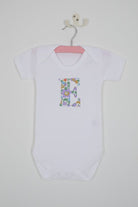 a personalised bodysuit baby grow with an initial cut from floral betsy purple Liberty print 