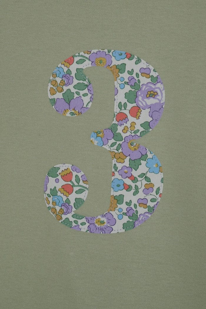 a birthday number 3 kids sage green t-shirt with a number cut from betsy purple floral liberty print on the front.