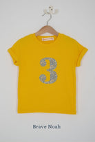a yellow birthday t-shirt with a number 3 cut from brave noah liberty print on the front.