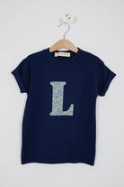 a personalised kids navy t-shirt with an letter cut from brave noah dragons print on the front