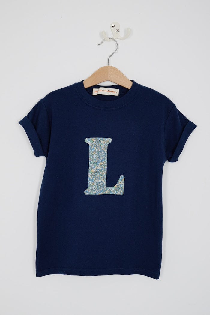 a personalised kids navy t-shirt with an letter cut from brave noah dragons print on the front