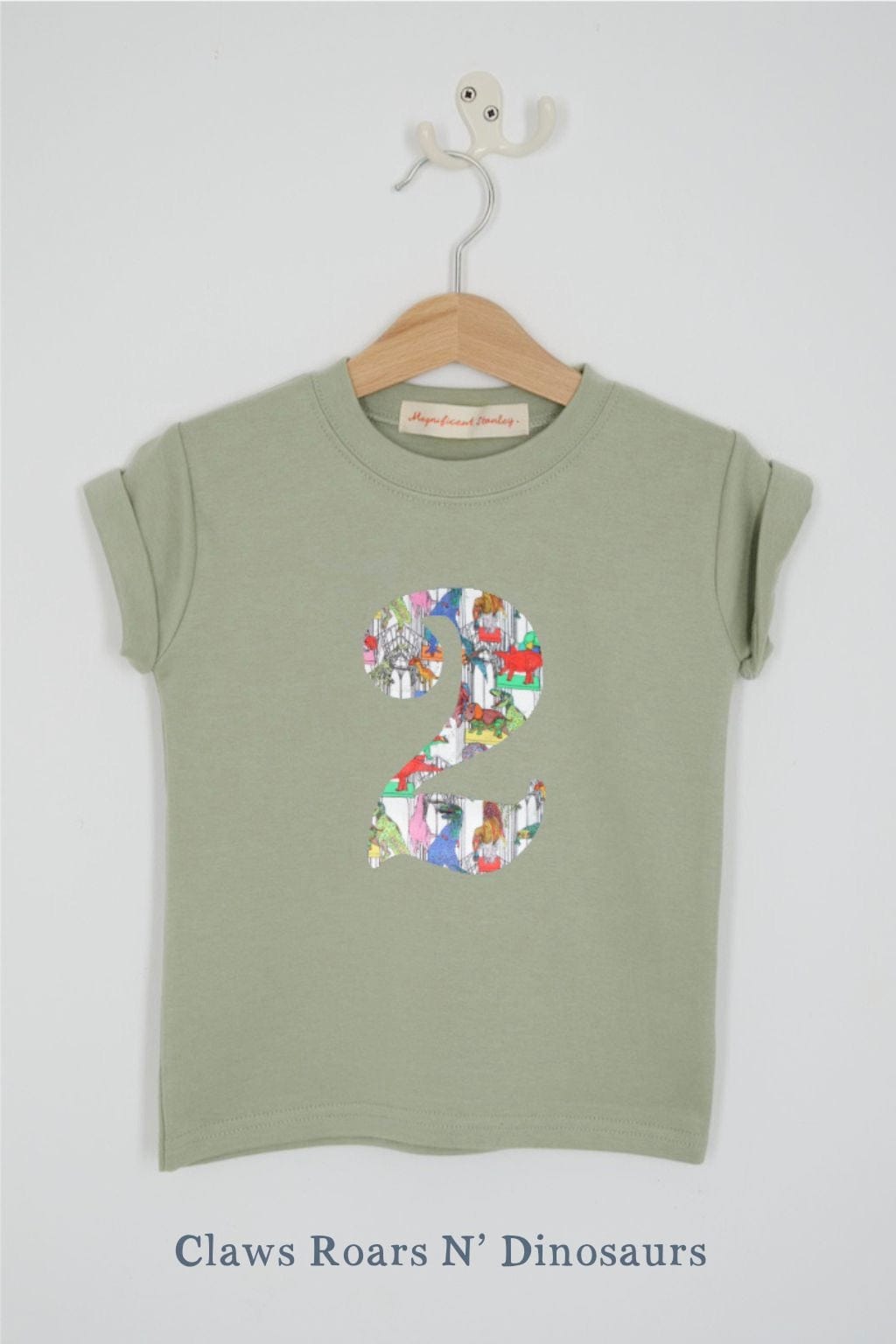 a number 2nd birthday kids sage green t-shirt with a number cut from claws roars n' dinosaurs liberty print on the front.