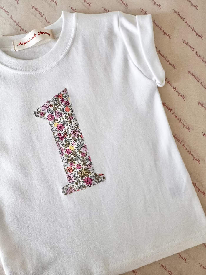 a white girl's birthday t-shirt with a liberty floral number one on the front.