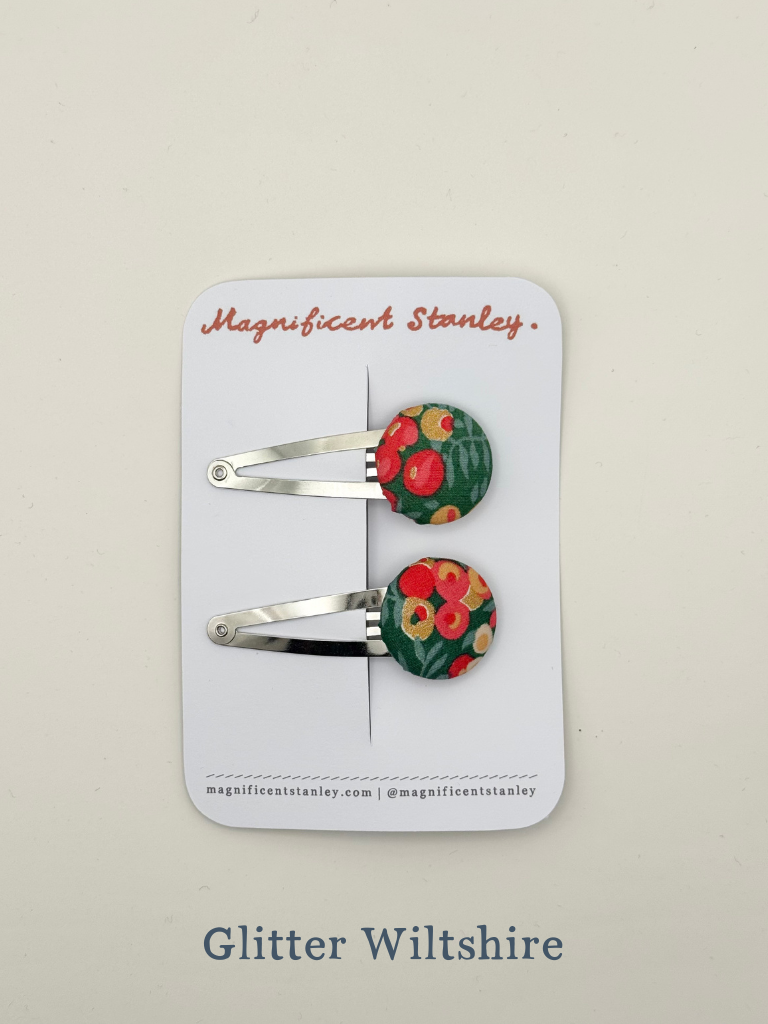 Pair of floral glitter wiltshire hair clips on a 'Magnificent Stanley' branded card.
