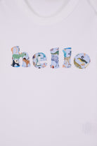 A close up of a white cotton babygrow with the word hello sewn on the front, cut from Quey 2 zoo animal  Liberty print.