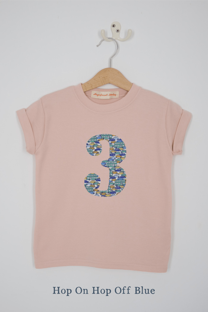 a pink 3rd birthday t-shirt with a number 3 cut from hop on hop off liberty london bus and car print on the front