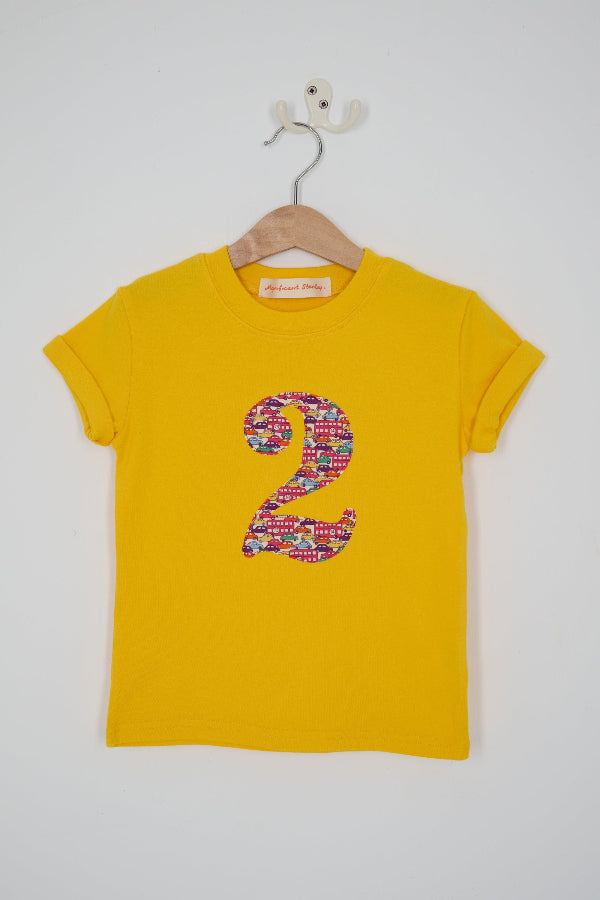 a yellow kids t-shirt with a number 3 cut from Hop on hop off red cars and london bus liberty print on the front.