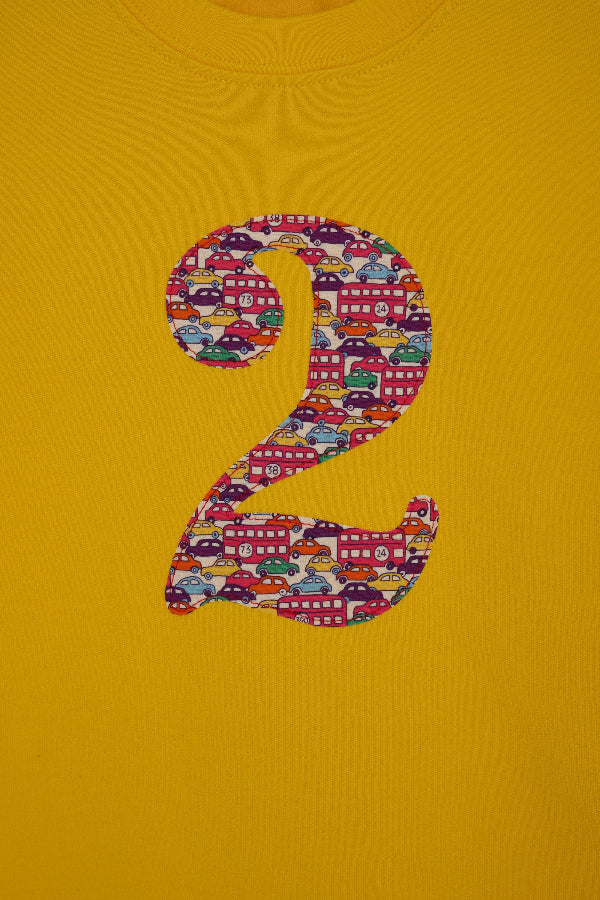 a yellow kids t-shirt with a number 3 cut from Hop on hop off red cars and london bus liberty print on the front.