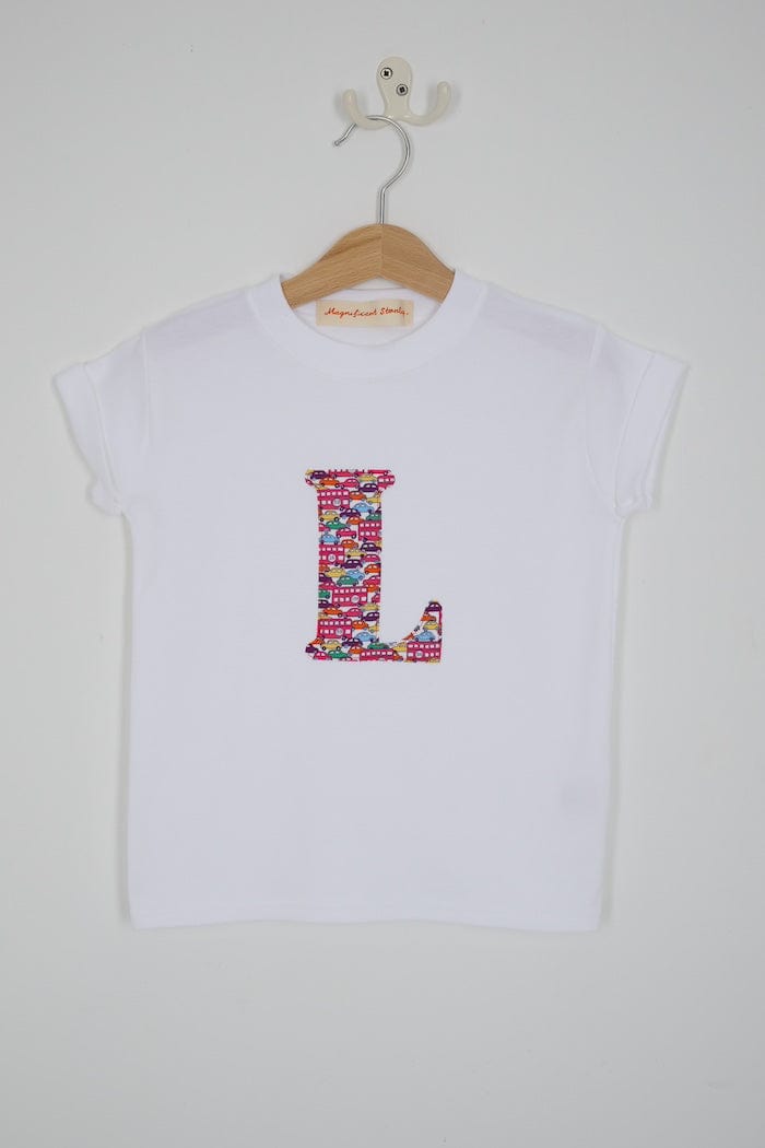 a personalised kids white t-shirt with an initial cut from Hop on hop off red cars and london bus liberty print on the front