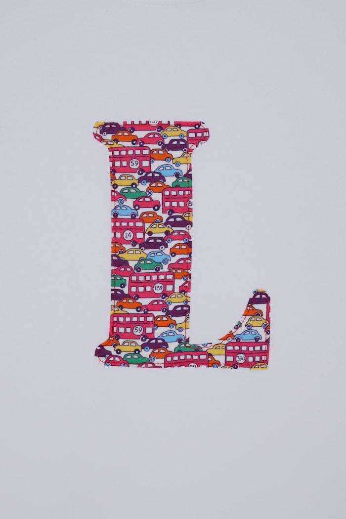 a personalised kids white t-shirt with an initial cut from Hop on hop off red cars and london bus liberty print on the front
