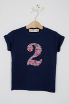 a personalised kids navy t-shirt with an initial cut from hop on hop off liberty print featuring london buses and vintage cars