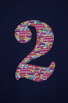 a personalised kids navy t-shirt with an initial cut from hop on hop off liberty print featuring london buses and vintage cars.