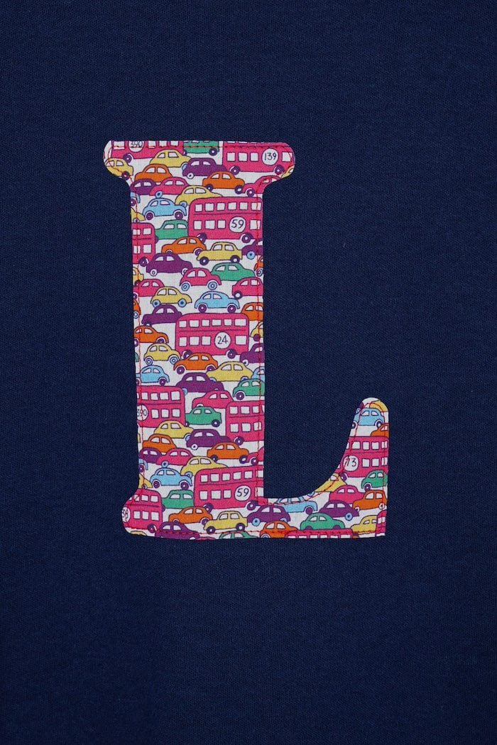 a navy cotton kids t-shirt with the letter 'L' personalised in a red Hop on hop off Liberty print. a close up of the stitching