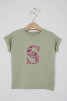 a personalised kids sage green t-shirt with an initial cut from hop on hop off red london bus and cars liberty print on the front.