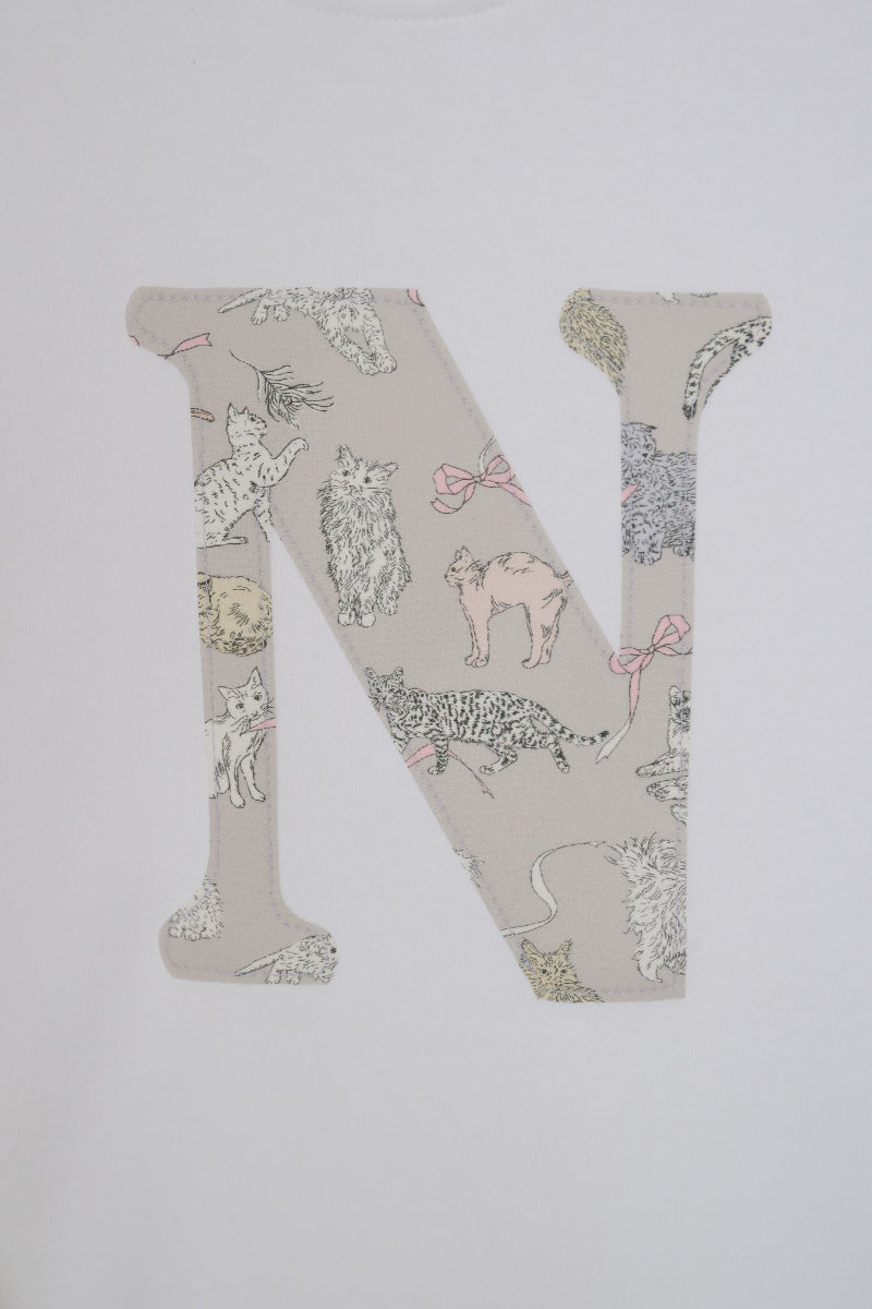 A large embroidered letter 'N' featuring a Liberty Koh & Eito cat print on a light beige background, shown on a plain white fabric.