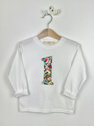White long-sleeve shirt with a Liberty Thorpe floral number '1' on a hanger against a white background