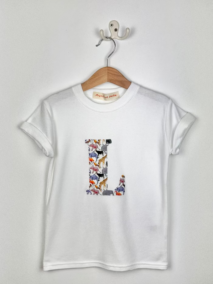 White t-shirt with colorful 'L' design on a hanger against a white background