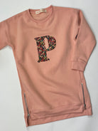Pink sweatshirt dress with Liberty floral letter 'P' on a white background