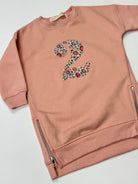 Pink sweatshirt dress with a liberty floral number '2' on a white background