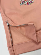 Pink sweatshirt dress with a liberty floral design showing the side zips area.