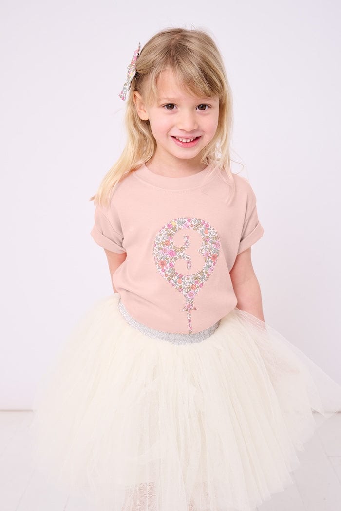 a 3 year old girl wearing a pink t-shirt with a balloon with the number 3 on it cut from floral Liberty print