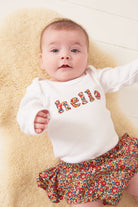 Magnificent Stanley Bodysuit 'hello' Bodysuit in choice of Liberty Print Magnificent Stanley Bodysuit 'hello' Bodysuit. New baby wears a white bodysuit with the word hello on it. the letters are cut from floral liberty print 