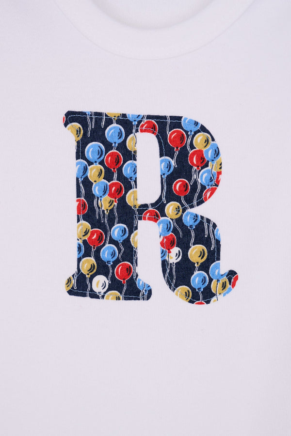  a Personalised Bodysuit in Ethan's Party Liberty Print, a close up showing the applique stitching