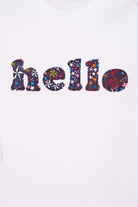 Close up of a white cotton romper with the word hello on it. the letters are cut from starry liberty print and appliquéd onto the romper