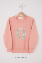 A pink personalised sweatshirt with an initial sewn on to the front. The initial is made from pink floral liberty print