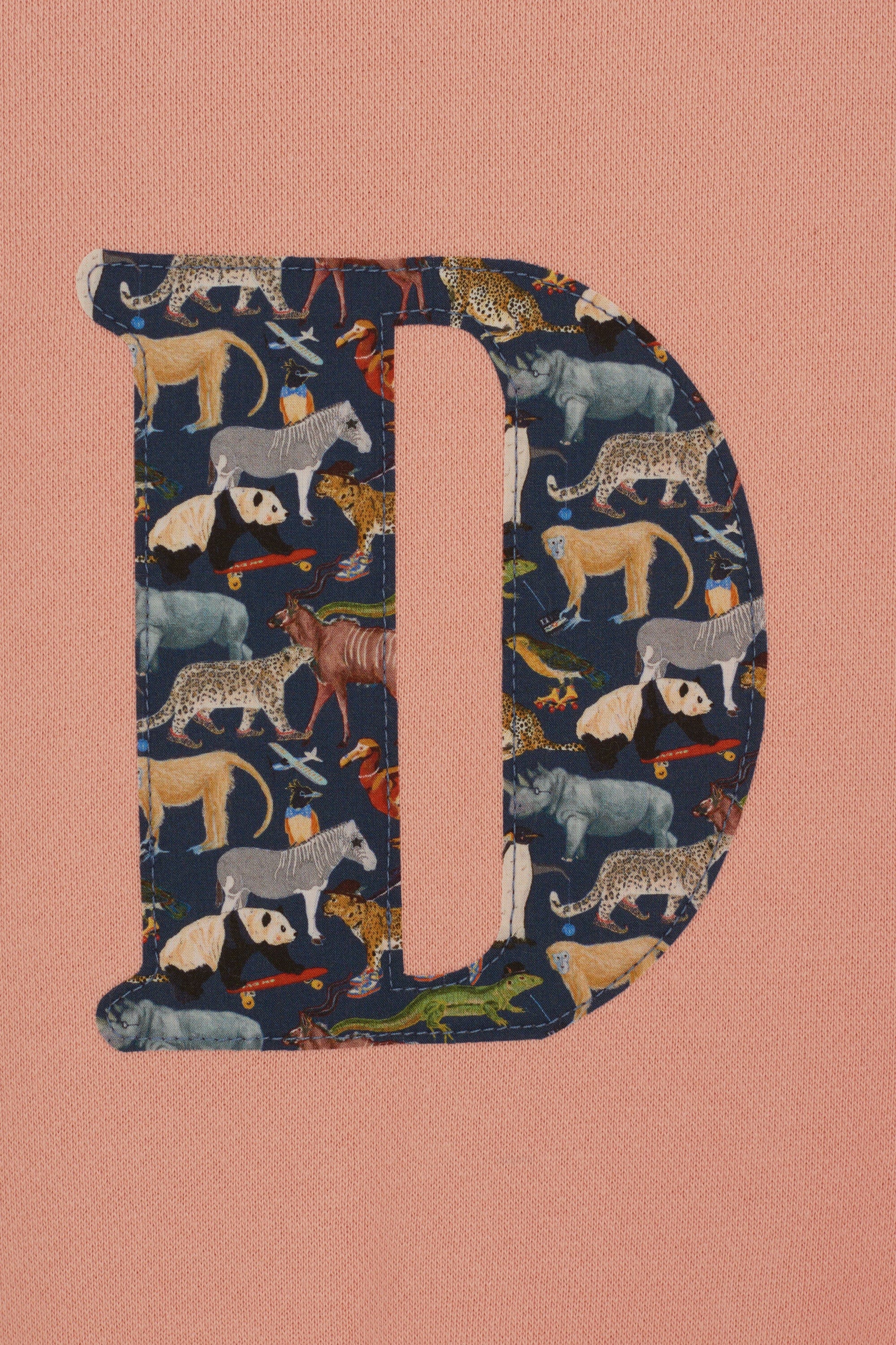 a personalised dusty pink sweatshirt with an initial on in floral Quey 2 Liberty print on the front.