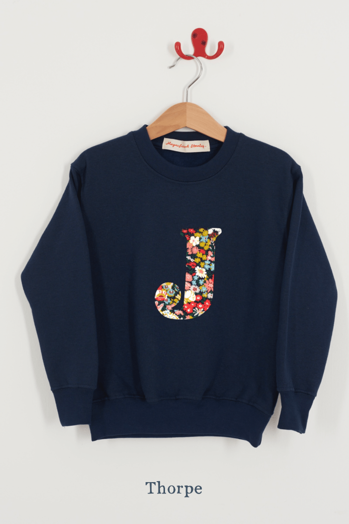 A personalised navy kids sweatshirt with an initial on in Thorpe floral Liberty fabric.