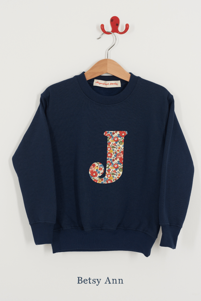 A personalised navy sweatshirt with an initial on in Betsy Ann Liberty fabric.