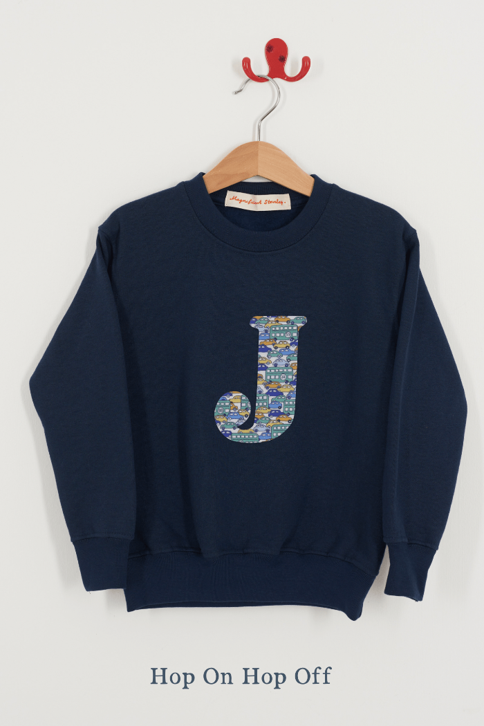 A Magnificent Stanley kids personalised Navy Sweatshirt with an initial on the front in hop on hop off cars liberty print.