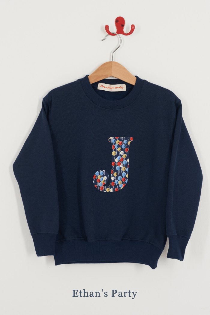 A personalised navy sweatshirt with an initial on in Balloon Liberty fabric.