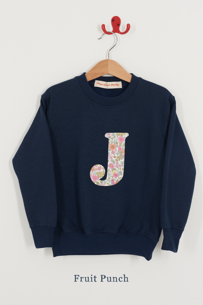 A personalised kids navy sweatshirt with an initial on in Floral Liberty fabric.