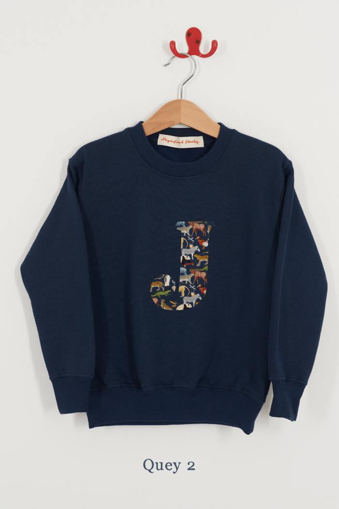 A personalised kids navy sweatshirt with an initial on in Quey 2 zoo animal Liberty fabric.
